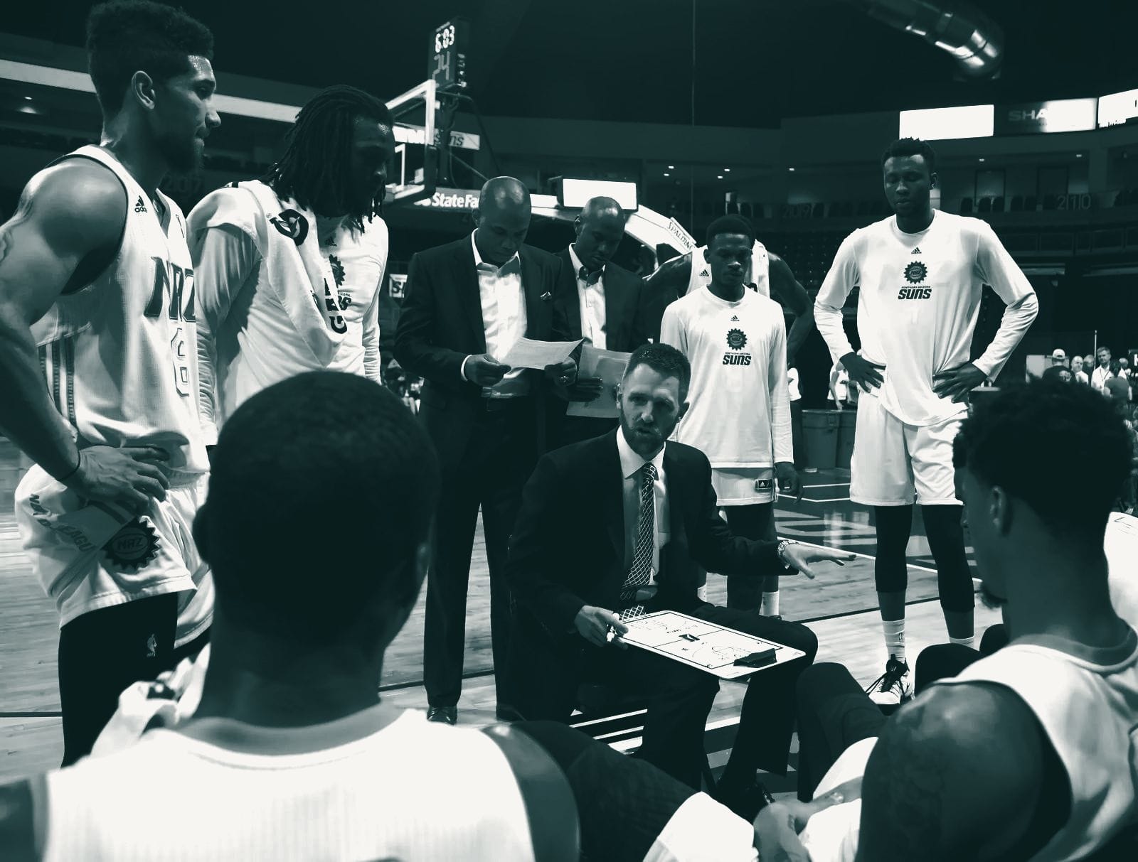 A coach in the huddle with his players